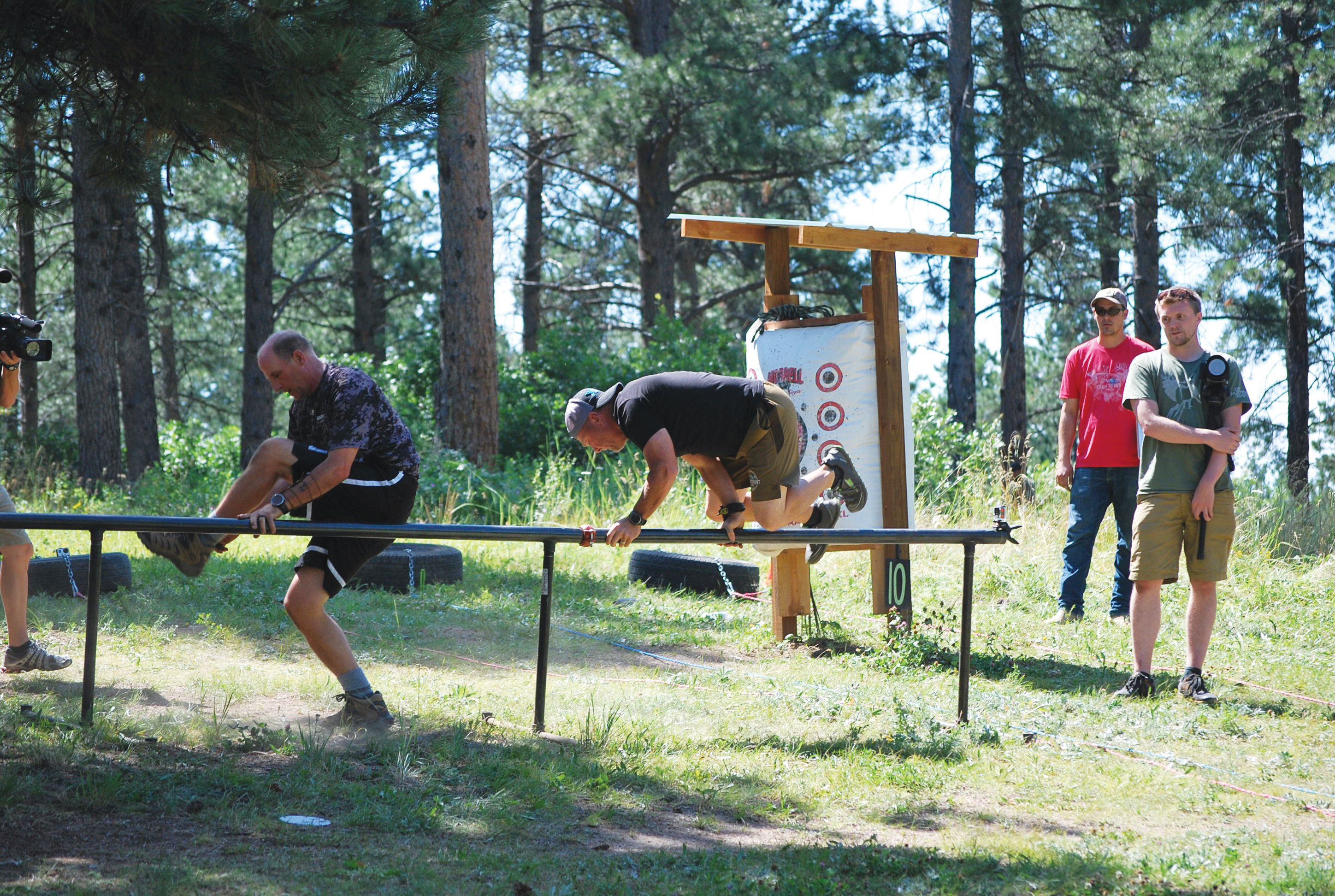 Men training with rail in wilderness