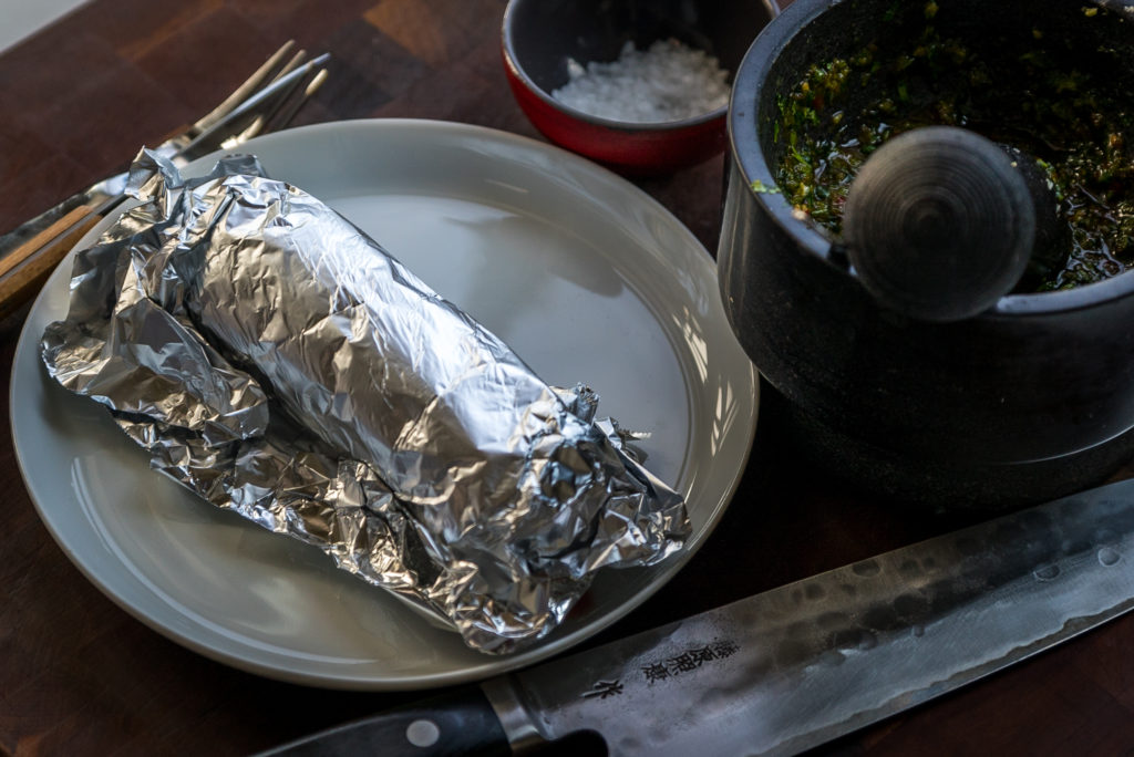 Game meat resting in aluminum foil on plate